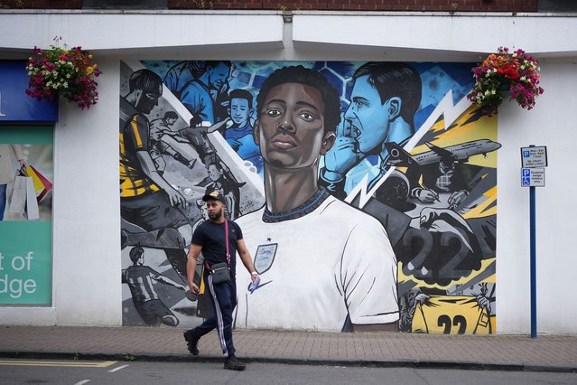 Locals walk past a mural of footballer Jude Bellingham in his hometown of Stourbridge on July 01, 2024 in Stourbridge, England. Jude Bellingham kept England's hopes alive in the UEFA Euro 2024 tournament after last night's last-minute goal against Slovakia to tie the match, paving the way for an extra-time victory to send England to the quarter finals. (Photo by Christopher Furlong/Getty Images)