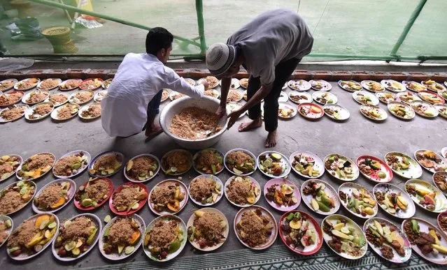 Indian Muslim men arrange rows of food for Iftar, the time for break the fast during the first day of the month of Ramadan in Guwahati on May 28, 2017. Like millions of Muslim around the world, Indian Muslims celebrated the month of Ramadan by abstaining from eating, drinking, and smoking as well as sexual activities from dawn to dusk. (Photo by Biju Boro/AFP Photo)