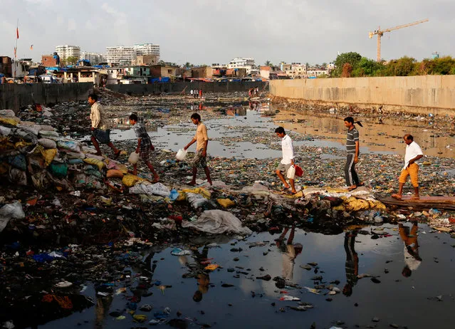 Residents cross a polluted water canal at a slum on the World Environment Day in Mumbai, India, June 5, 2017. (Photo by Danish Siddiqui/Reuters)