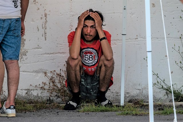 A survivor of a shipwreck stands outside a warehouse at the port in Kalamata town, on June 14, 2023, after a boat carrying dozens of migrants sank in international waters in the Ionian Sea. - Greece has declared three days of mourning, the interim prime minister's office said on June 14, 2023, over a migrant boat sinking in the Ionian Sea feared to have claimed hundreds of lives. The Greek coastguard has so far recovered 79 bodies and rescued over 100, but survivors are claiming that up to 750 people were on board. (Photo by Angelos Tzortzinis/AFP Photo)