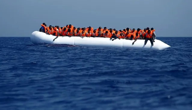 Migrants on a rubber dinghy wait to be rescued by the Migrant Offshore Aid Station (MOAS) ship MV Phoenix, some 20 miles (32 kilometres) off the coast of Libya, August 3, 2015. (Photo by Darrin Zammit Lupi/Reuters)