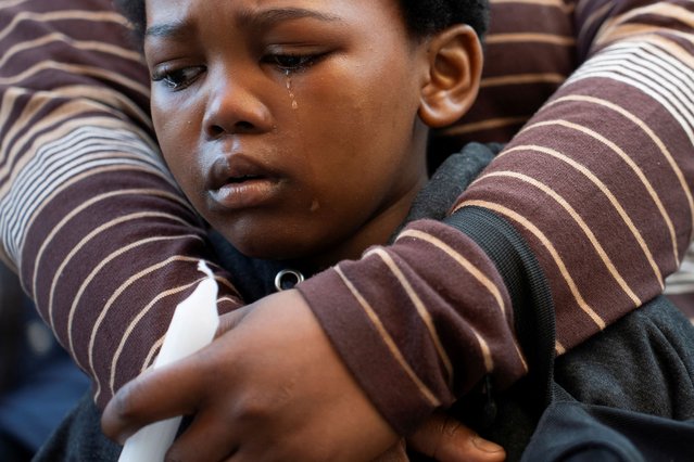 A young boy sheds a tear as he mourns at the site of the fire that killed over 70 people in the Usindiso building, during the one-year anniversary commemoration outside the destroyed building in Johannesburg, South Africa, on August 31, 2024. (Photo by Ihsaan Haffejee/Reuters)