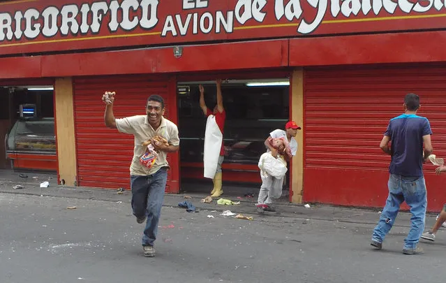 This photo provided by Heibort Barrios shows people running off with meat from a butcher shop, as an employee reaches to close the shop entrance in Turmero, Aragua state, near Maracay, Venezuela, Wednesday, June 28, 2017. Dozens of supermarkets, pharmacies and liquor stores were looted and several government offices burned during the incident, following anti-government protests. (Photo by Heibort Barrios via AP Photo)