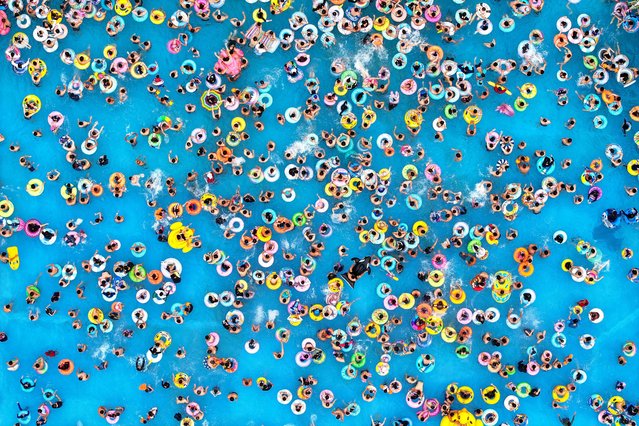 This aerial photo taken on June 23, 2023 shows people cooling off at a water park in Nanjing, in China's eastern Jiangsu province. (Photo by AFP Photo/China Stringer Network)