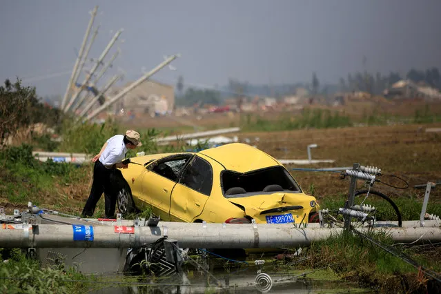 A man looks at a damaged car after a tornado hit Funing on Thursday, in Yancheng, Jiangsu province, June 25, 2016. (Photo by Aly Song/Reuters)