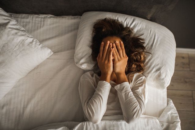 Woman in depression closed face with hands and crying in bed. Melancholy mood, mental health. Life problems. (Photo y Oleg Breslavtsev/Getty Images)