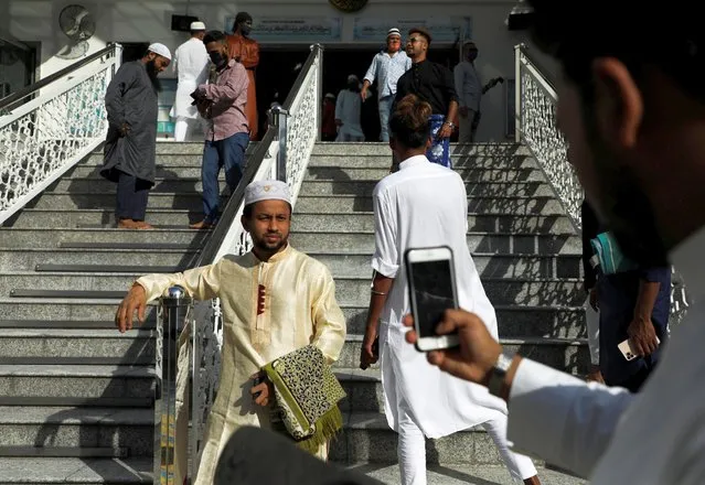 A south Asia migrant takes picture of his friend as they celebrate Eid al-Fitr, marking the end of the holy fasting month of Ramadan, in Kuala Lumpur, Malaysia, May 2, 2022. (Photo by Hasnoor Hussain/Reuters)