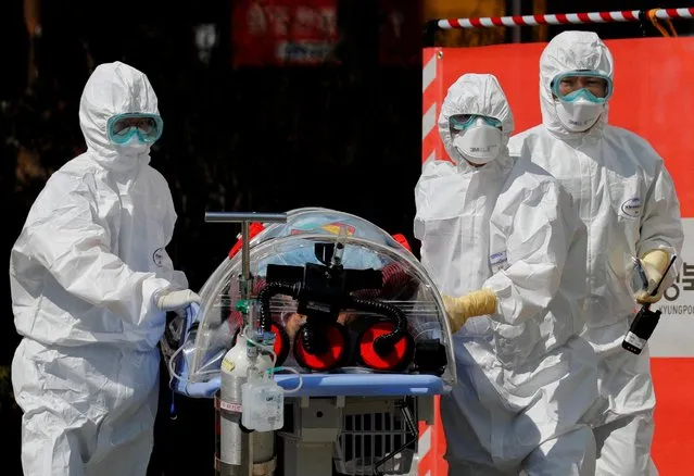 Medical workers carry a patient who are suspected of having coronavirus disease (COVID-19) in a Negative Pressure Isolation stretcher into a facility of Kyungpook National University Hospital in Daegu, South Korea, March 6, 2020. (Photo by Kim Kyung-Hoon/Reuters)