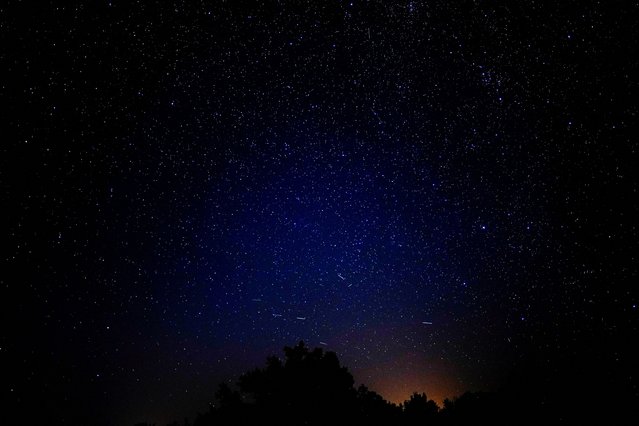 Meteors streak past stars in the night sky during the annual Perseid meteor shower above Santo Tome del Puerto, in Segovia, Spain on August 12, 2024. (Photo by Ana Beltran/Reuters)