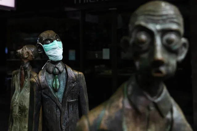 A face mask is placed on one of the 'Three business men who brought lunch' statues on Swanston street on March 29, 2020 in Melbourne, Australia. All international arrivals into Australia from midnight on Saturday will be placed into mandatory quarantine in hotels for 14 days as the Federal Government increases restrictions to stop the spread of COVID-19. All libraries, museums, galleries, beauty salons, tattoo parlours, shopping centre food courts, auctions, open houses, amusement parks, arcades, indoor and outdoor play centres, swimming pools are closed and indoor exercise activities are now banned. This is in addition to the closure of bars, pubs and nightclubs which came into effect on Monday. Restaurants and cafes are restricted to providing takeaway only. Weddings will now be restricted to five people including the couple while funerals are limited to 10 mourners. All Australians are now expected to stay at home except for essential outings such as work, grocery shopping and medical appointments. Exercising outdoors alone is still permitted. Australia now has more than 3,600 confirmed cases of COVID-19 while the death toll now stands at 16. (Photo by Asanka Ratnayake/Getty Images)