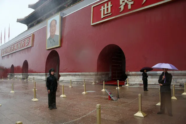 Paramilitary police officers hold umbrellas as they stand in front of the Tiananmen Gate and a giant portrait of Chinese late Chairman Mao Zedong on a day of heavy rain in Beijing, China, July 20, 2016. (Photo by Thomas Peter/Reuters)