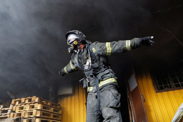 A firefighter works to put out fire at a warehouse that was hit by shelling in the course of Russia-Ukraine conflict in Donetsk, Russian-controlled Ukraine on October 21, 2023. (Photo by Alexander Ermochenko/Reuters)