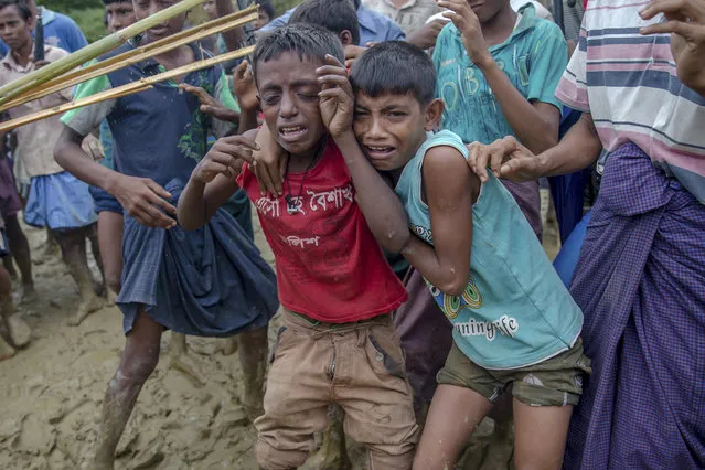 In this Wednesday, September 20, 2017, file photo, Rohingya Muslim boys, who crossed over from Myanmar into Bangladesh, cry as Bangladeshi men push them away during distribution of food aid near Balukhali refugee camp, Bangladesh. Children make up about 60 percent of the sea of humanity that has poured in to Bangladesh over the last four weeks fleeing terrible persecution in Myanmar. And the UN’s child rights agency UNICEF has so far counted about 1,400 children who have crossed the border without their parents. (Photo by Dar Yasin/AP Photo)