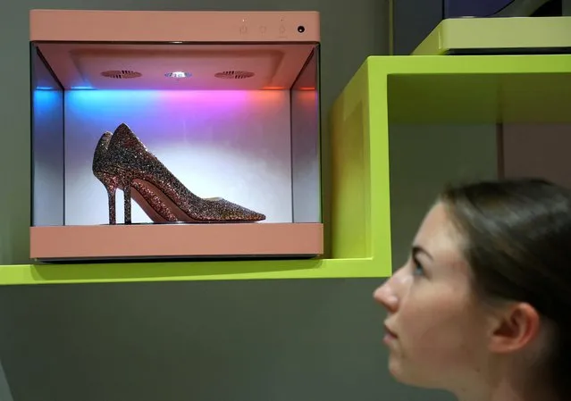 A model looks at the LG Styler ShoeCare, a display case that takes care of stinky soles with advanced technology, can keep shoes safe from moisture and has filters to protect them from UV light, made by LG Electronics during it's presentation at the IFA consumer technology fair, in Berlin, Germany on September 1, 2022. (Photo by Fabrizio Bensch/Reuters)