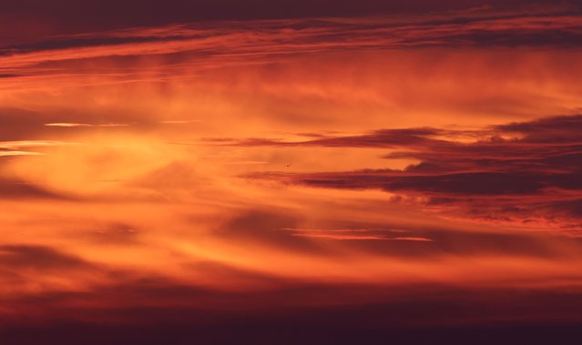 The sun rises over the Kraichgau mountains pictured in Gaiberg near Heidelberg, southern Germany, on October 18, 2024. (Photo by Daniel Roland/AFP Photo)