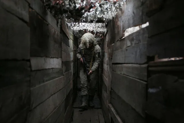 Ukrainian soldier walks along a trench on the frontline with Russia-backed separatists, not far from town of Avdiivka, Donetsk region, on December 10, 2021. (Photo by Anatolii Stepanov/AFP Photo)