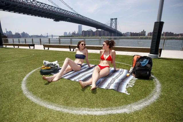 Jennifer (red) from Brooklyn and her friend Noelle (black) visiting from Philadelphia get some sun at Domino Park in Brooklyn on June 10, 2020. (Photo by Brian Zak/The New York Post)