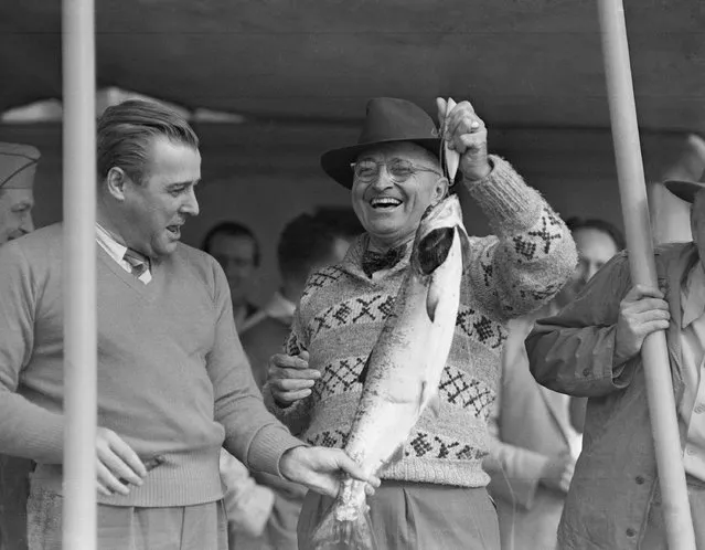 President Harry Truman and U.S. Sen. Warren Magnuson, left, grin happily as they admire a salmon held by the President on Puget Sound fishing trip to Washington  June 21, 1945 – even though the fish was a gift. The Presidential party had a lot of fun but not much fishing luck. (Photo by AP Photo)
