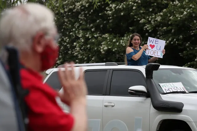 Joel Draut, a photographer, editor and photo archivist, waves toward former colleague Laney Chavez during a drive-by vehicle parade to celebrate his retirement amid the global outbreak of the coronavirus disease (COVID-19), in Katy, Texas, U.S., June 27, 2020. (Photo by Adrees Latif/Reuters)