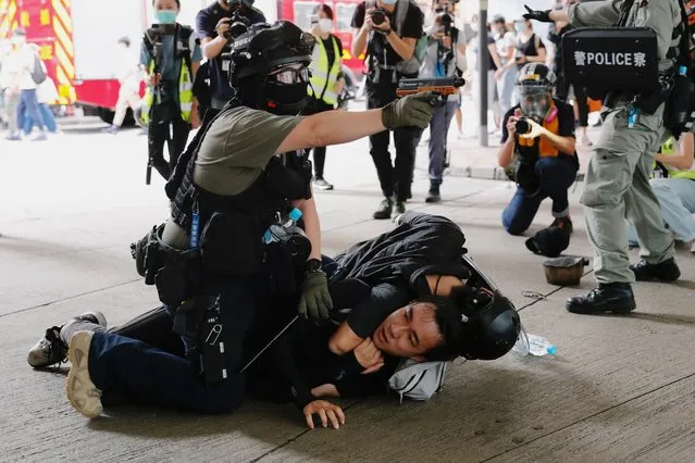 A police officer raises his pepper spray handgun as he detains a man during a march against the national security law at the anniversary of Hong Kong's handover to China from Britain in Hong Kong, China on July 1, 2020. (Photo by Tyrone Siu/Reuters)