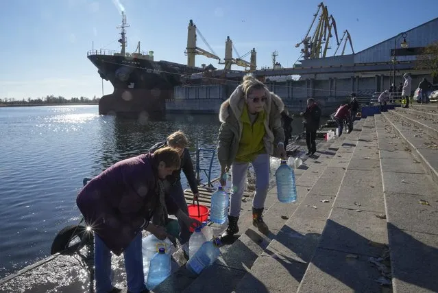 People collect water from a Dnipro river in Kherson, Ukraine, Tuesday, November 15, 2022. (Photo by Efrem Lukatsky/AP Photo)