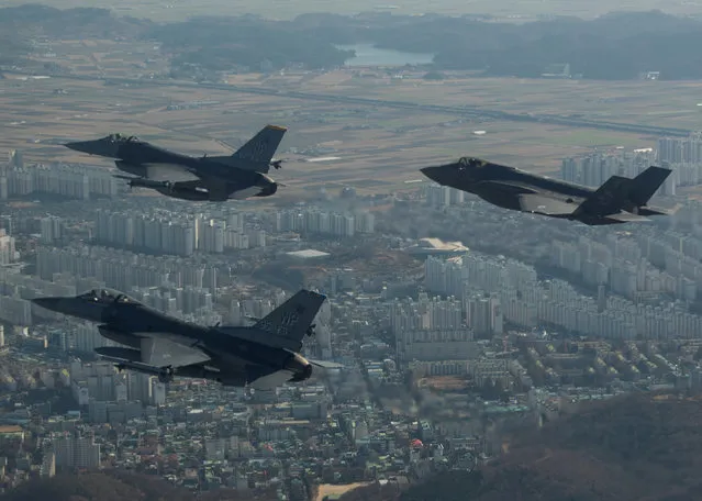 A U.S. Air Force F-35A Lightning II assigned to Hill Air Force Base, Utah, conducts a training flight with F-16 Fighting Falcons assigned to Kunsan Air Base, South Korea over the city of Gunsan, in South Korea on December 6, 2017. (Photo by Courtesy Josh Rosales/Reuters/U.S. Air Force)