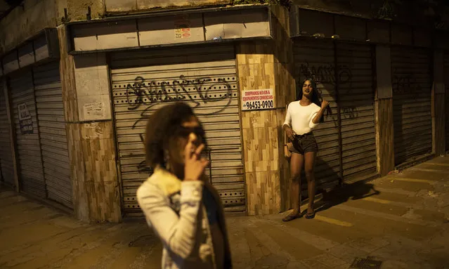 Transgender sеx worker Alice Larubia smokes a cigarette as she waits for customers in Niteroi, Brazil, Saturday, June 27, 2020, amid the new coronavirus pandemic. After a month quarantining at home with some financial support from family, Larubia resumed work in Niteroi, a city across the bay from Rio. “Necessity spoke louder (than the pandemic) and I had to come back to the street”, Larubia said while waiting for clients with a small group of colleagues. (Photo by Silvia Izquierdo/AP Photo)