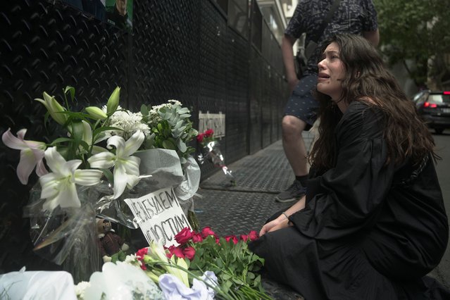 A woman cries as she places flowers outside the Russian Embassy in memory of Alexei Navalny in Buenos Aires, Argentina, Friday, February 16, 2024. Navalny, who crusaded against official corruption and staged massive anti-Kremlin protests as President Vladimir Putin's fiercest foe, died Friday in the Arctic penal colony where he was serving a 19-year sentence, Russia's prison agency said. He was 47. (Photo by Victor R. Caivano/AP Photo)