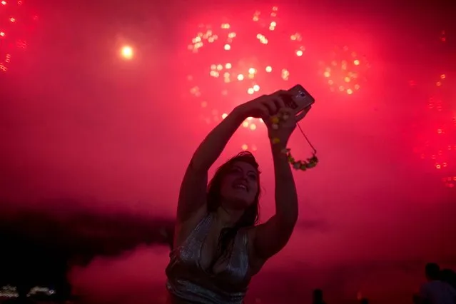 People take photos of fireworks during New Year's celebrations at Copacabana beach in Rio de Janeiro on January 1, 2018. (Photo by Mauro Pimentel/AFP Photo)