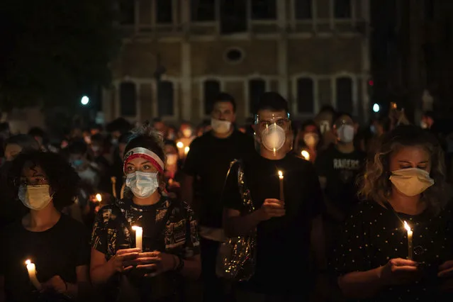 Demonstrators march holding candles honoring the victims of the deadly explosion at Beirut port which devastated large parts of the capital, in Beirut, Lebanon, Sunday, August 9, 2020. (Photo by Felipe Dana/AP Photo)