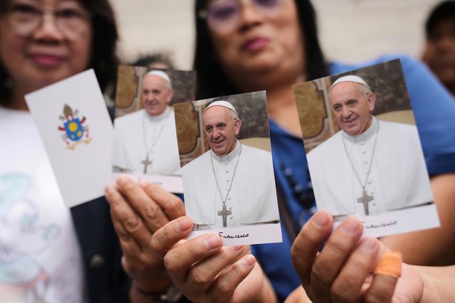 Indonesian women show portraits of the late Pope Francis as they wait for their turn to be allowed in to the Apostolic Nunciature to offer their condolences, in Jakarta, Indonesia, Tuesday, April 22, 2025. (Photo by Dita Alangkara/AP Photo)