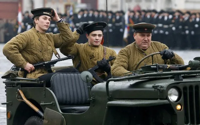Men dressed in historical uniforms drive a vehicle during a military parade in Red Square in Moscow November 7, 2014. (Photo by Maxim Shemetov/Reuters)