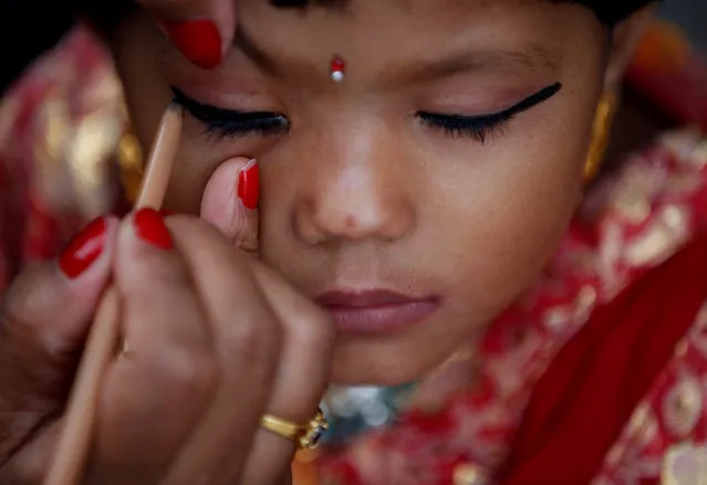 A woman applies makeup to a young girl dressed as the Living Goddess Kumari during the Kumari Puja festival in Kathmandu, Nepal September 14, 2016. (Photo by Navesh Chitrakar/Reuters)