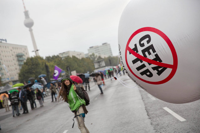 An activist hold a big balloon at a demonstration against two international trade agreements in Berlin, Germany, 17 September 2016. Protest marches and demontrations against the planned Comprehensive Economic and Trade Agreement (CETA) between Canada and the European Union (EU) and the Transatlantic Trade and Investment Partnership (TTIP) between the USA and EU were held simultaneously in several cities in Germany. (Photo by Jörg Carstensen/DPA)