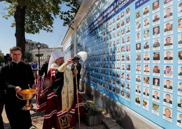 Metropolitan Epifaniy, the head of the Ukrainian Orthodox Church, blesses a rebuilt wall with portraits of Ukrainian defenders killed during an armed conflict in the eastern-Ukrainian conflict in Kiev, Ukraine, 20 August 2020. Ukrainians will mark the 29th anniversary of Ukraine's independence from the Soviet Union on 24 August 2020. (Photo by Sergey Dolzhenko/EPA/EFE/Rex Features/Shutterstock)