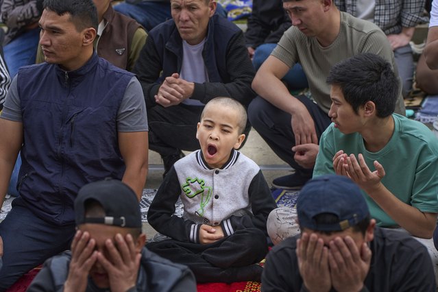 A boy yawns as other Muslims offer Eid al-Adha prayers at the Moscow Cathedral Mosque during celebrations in Moscow, Russia, Friday, June 6, 2025. (Photo by Alexander Zemlianichenko/AP Photo)