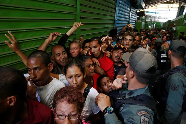 Venezuelan soldiers control the crowd as people queue trying to buy basic food during a special inspection to a municipal market in Caracas, Venezuela July 15, 2016. (Photo by Carlos Garcia Rawlins/Reuters)