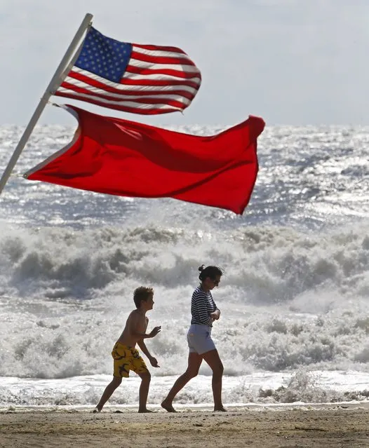 Beachgoers walk away from big waves and rough surf caused by Hermine, Sunday, September 4, 2016, in Bradley Beach,N.J. No swimming was allowed because of the passing storm. (Photo by Noah K. Murray/The Asbury Park Press via AP Photo)