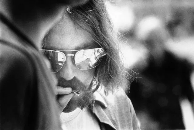 A long-haired hippie puffs on a cigarette during entertainment at the Texas International Pop Festival in Lewisville, Texas on September 1, 1969. The festival in its final round is expected to draw a total attendance of 200,000 people. A first aid tent was kept active treating persons on bad trips from drugs as well as persons suffering from the heat. (Photo by AP Photo)