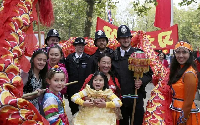 Supporters of China's President Xi Jinping pose for a picture with police officers as they wait on the Mall for him to pass during his ceremonial welcome, in London, Britain, October 20, 2015. (Photo by Neil Hall/Reuters)