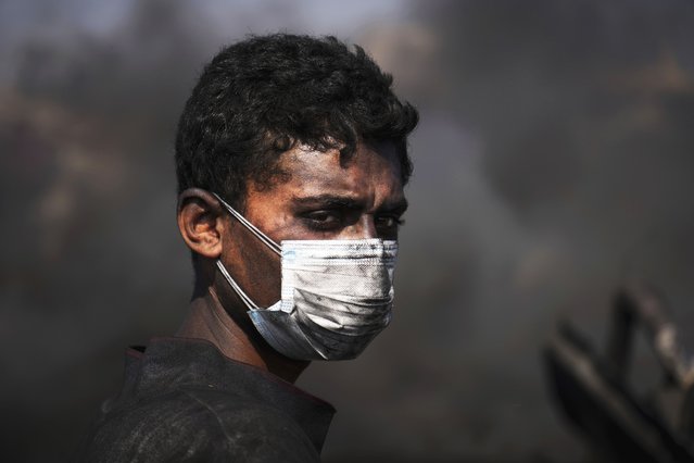 Mohammed Najm pauses while working at a makeshift burner used to extract fuel from melted plastic to sell along the Sea Road, south of Gaza City, Sunday, June 22, 2025. (Photo by Abdel Kareem Hana/AP Photo)