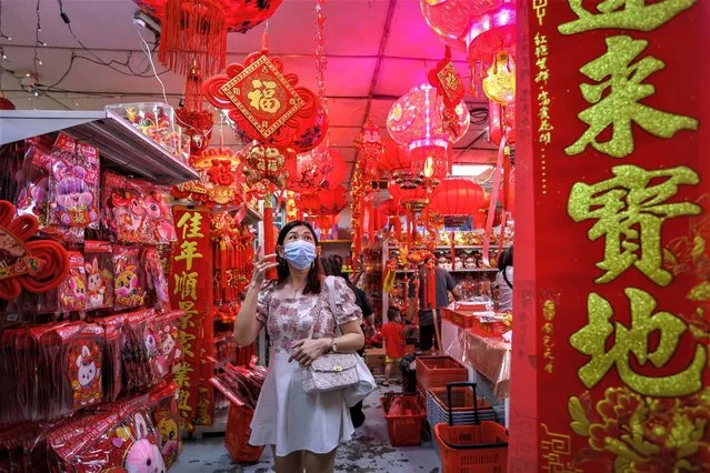 A woman shops for Lunar New Year decorations at Petaling Street, Chinatown on January 15, 2023 in Kuala Lumpur, Malaysia. (Photo by Annice Lyn/Getty Images)