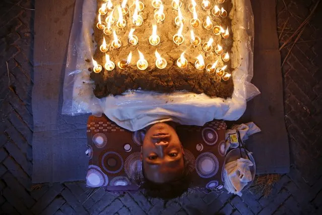A devotee offers oil lamps on top of his body as part of a ritual during Dashain, the biggest religious festival for Hindus in Bhaktapur, Nepal, October 22, 2015. (Photo by Navesh Chitrakar/Reuters)