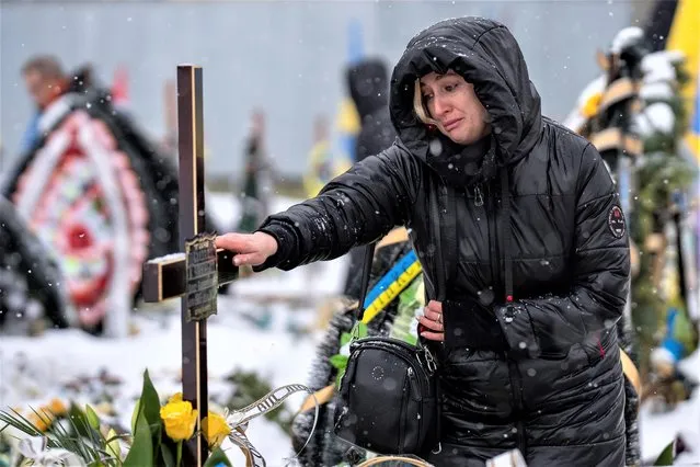 Nataliya cries at the grave of her brother Oleg Kunynets, a Ukrainian military servicemen who were killed in the east of the country, during his funeral in Lviv, Ukraine, Tuesday, February 7, 2023. (Photo by Emilio Morenatti/AP Photo)