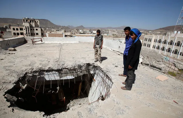 Boys stand by a hole caused by a Saudi-led air strike on the roof of their school last year, as schools open this week in Sanaa, the capital of war-torn Yemen October 5, 2016. (Photo by Khaled Abdullah/Reuters)