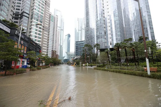 A road is submerged in flood waters caused by typhoon Chaba as a luxury apartment complex is seen in the background in Busan, South Korea, October 5, 2016. (Photo by Cho Jung-ho/Reuters/Yonhap)