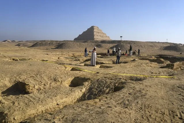 Egyptian antiquities workers dig at the site of the Step Pyramid of Djoser in Saqqara, 24 kilometers (15 miles) southwest of Cairo, Egypt, Thursday, January 26, 2023. Egyptian archaeologist Zahi Hawass, the director of the Egyptian excavation team, announced that the expedition found a group of Old Kingdom tombs dating to the fifth and sixth dynasties of the Old Kingdom, indicating that the site comprised a large cemetery. (Photo by Amr Nabil/AP Photo)