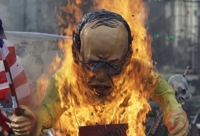 Activists burn a 14-foot (4.3-metre) tall effigy of President Benigno Aquino during a protest rally outside the presidential palace in Manila December 10, 2014, in observance of the Human Rights Day. The protesters gathered outside the presidential palace on Wednesday to protest the administration's alleged inaction on widespread human rights violations in the country, according to a statement from the group. (Photo by Romeo Ranoco/Reuters)