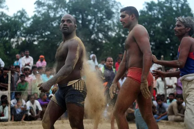 Indian wrestlers take part in a traditional wrestling competition at a local fair held annually in Rampur village, near Allahabad, India, October 7, 2016. (Photo by Sanjay Kanojia/AFP Photo)