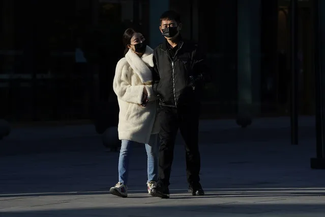 A couple wears masks to protect from the coronavirus as they visit a commercial district in Beijing on Friday, November 20, 2020. (Photo by Ng Han Guan/AP Photo)